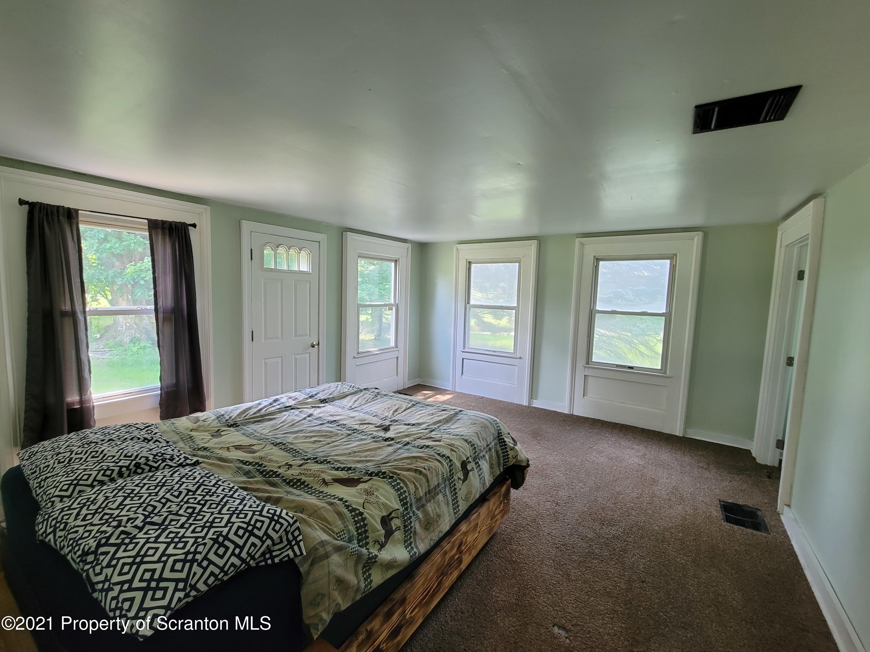 686 Wilcox Road Meshoppen, PA 18630 - Photo 17 of 30 a bed sitting in a spacious bedroom next to a window and closet