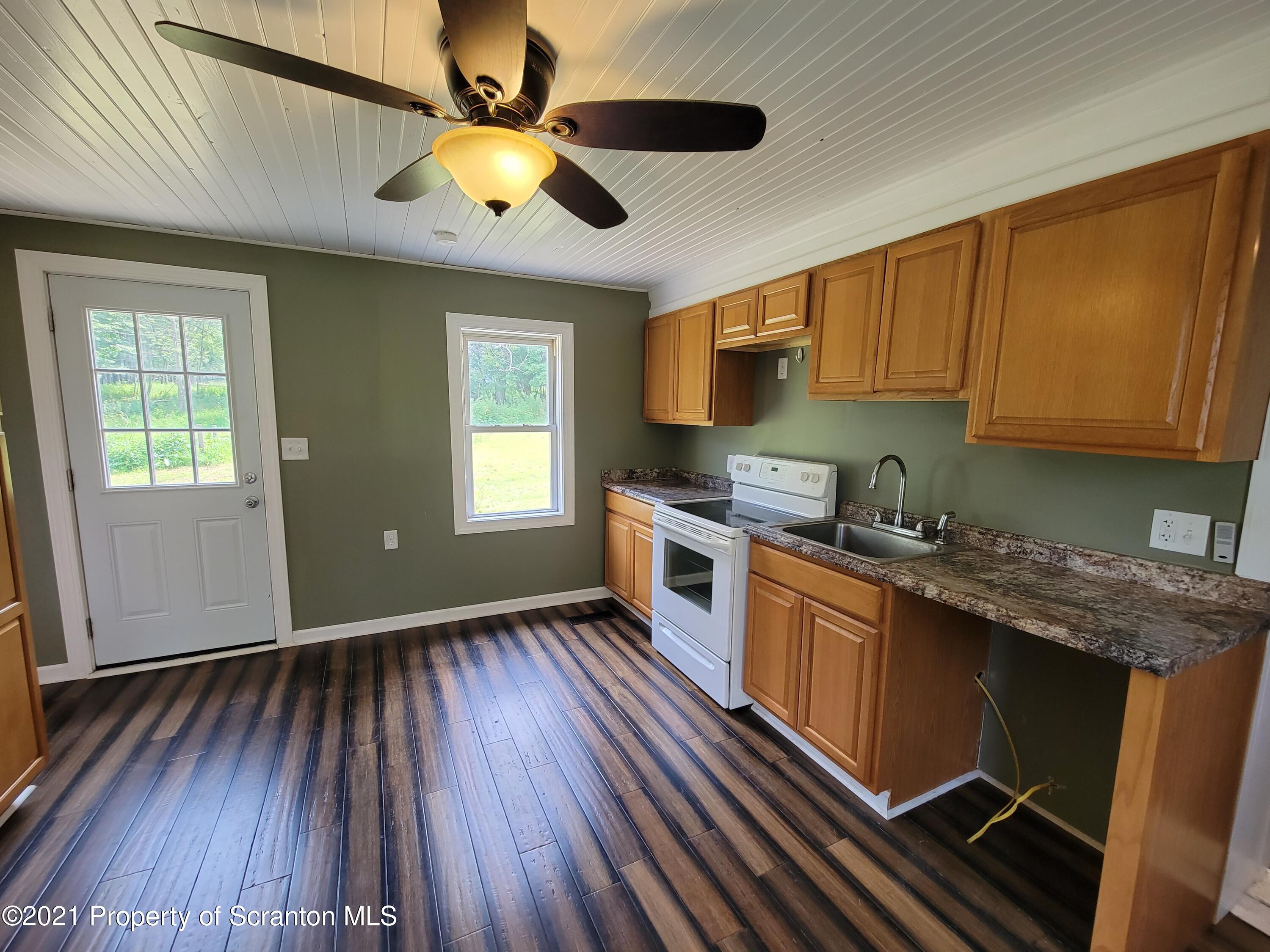 686 Wilcox Road Meshoppen, PA 18630 - Photo 10 of 30 a kitchen with granite countertop wooden floors a sink and appliances