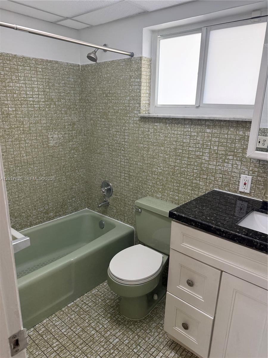 6841 Pembroke Road, Unit 15 Pembroke Pines, FL 33023 - Photo 11 of 16 a bathroom with a granite countertop toilet a sink and bathtub