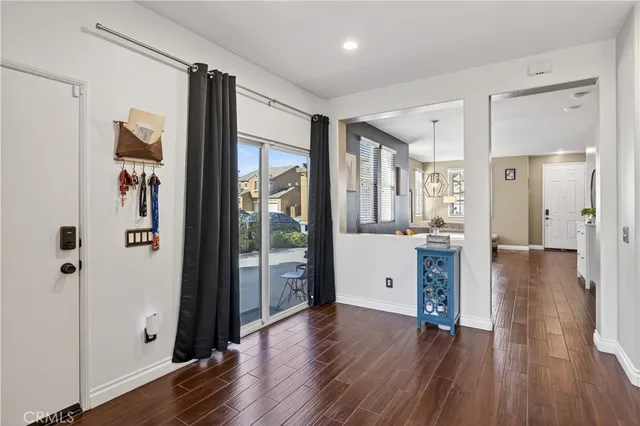 a view of a hallway with wooden floor and a bathroom