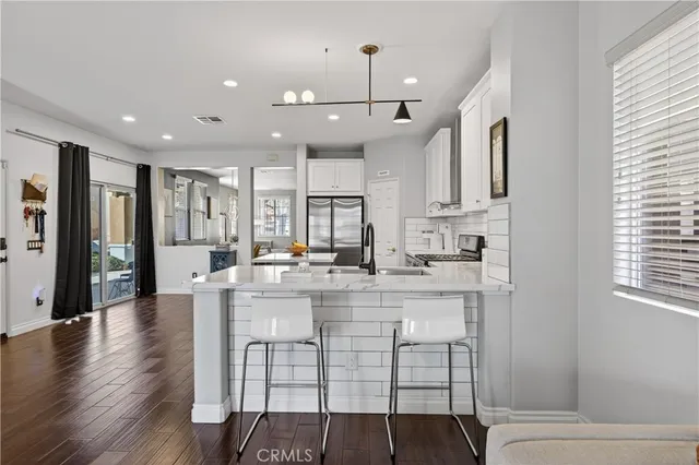 a kitchen with kitchen island stainless steel appliances a dining table and chairs