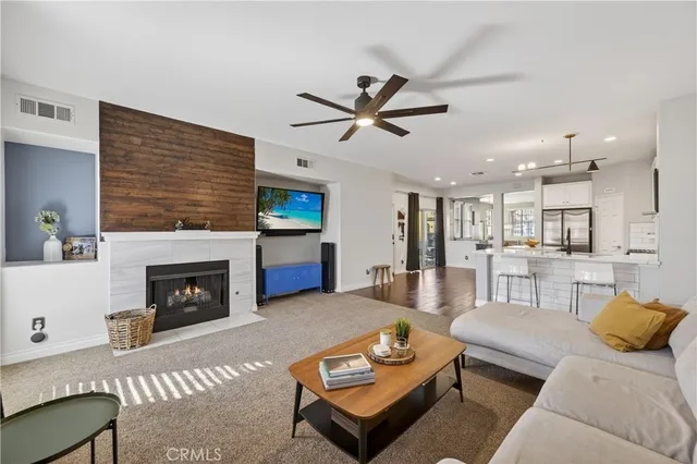 a living room with furniture a fireplace and a ceiling fan