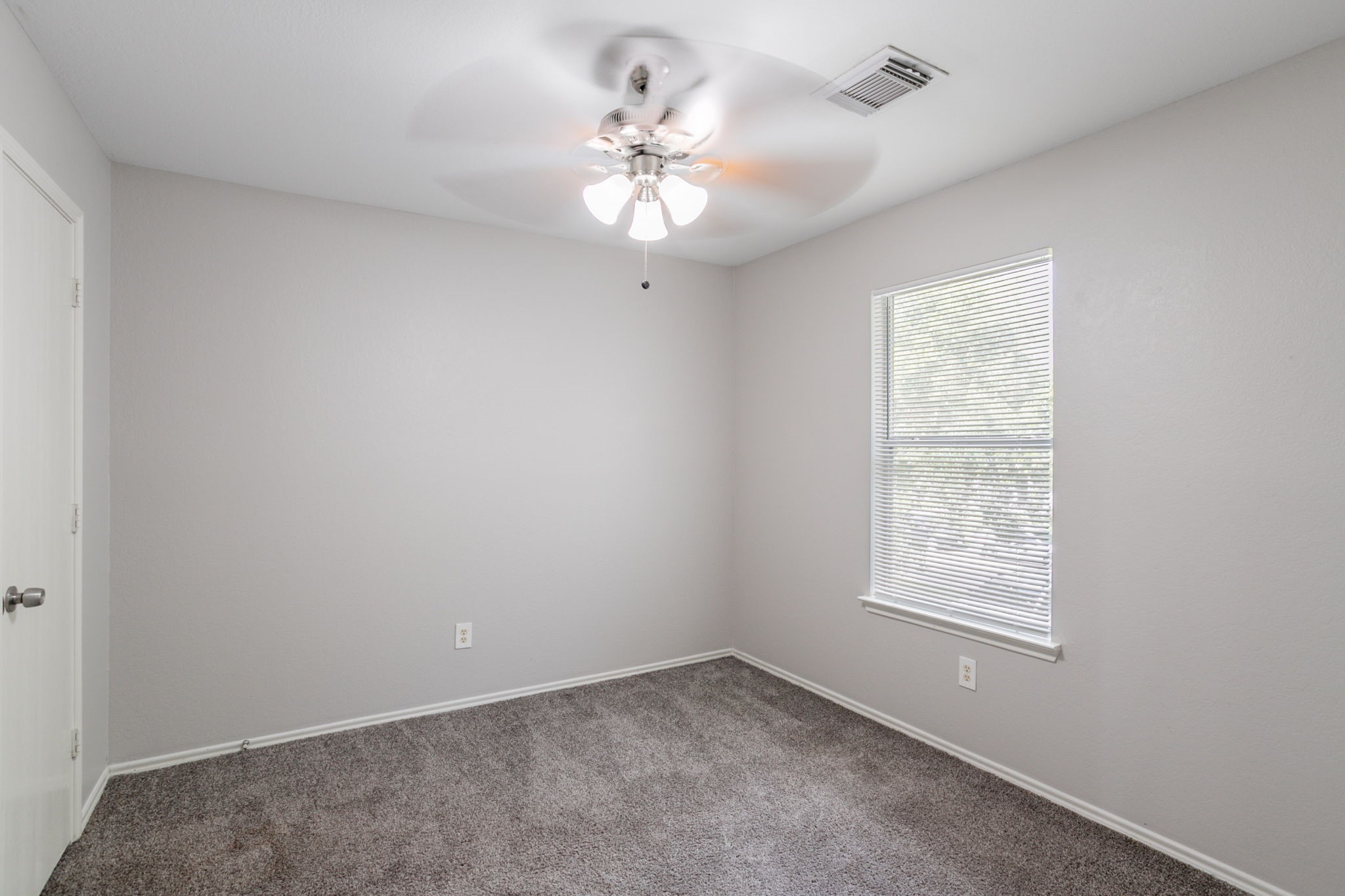 12026 Madison Oak Street Houston, TX 77038 - Photo 11 of 39 an empty room with windows and fan