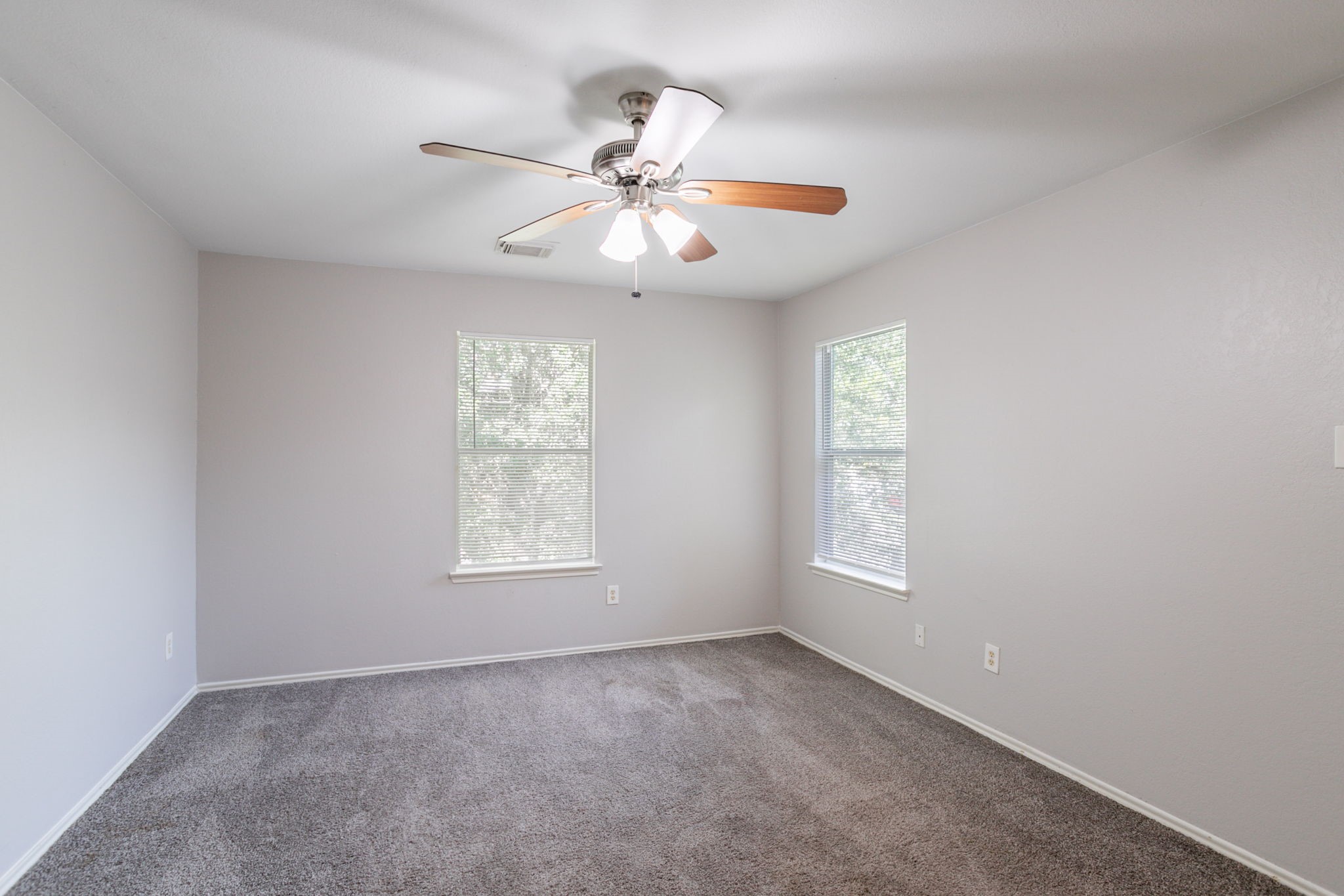12026 Madison Oak Street Houston, TX 77038 - Photo 12 of 39 an empty room with windows and fan
