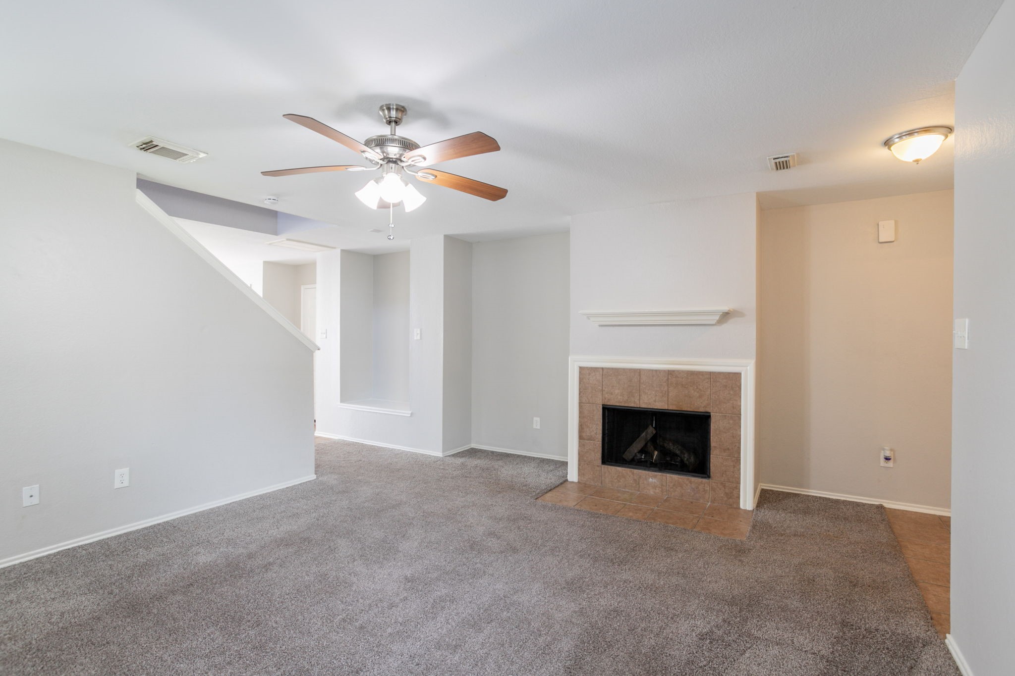 12026 Madison Oak Street Houston, TX 77038 - Photo 15 of 39 a view of an empty room with chandelier fan and fire place