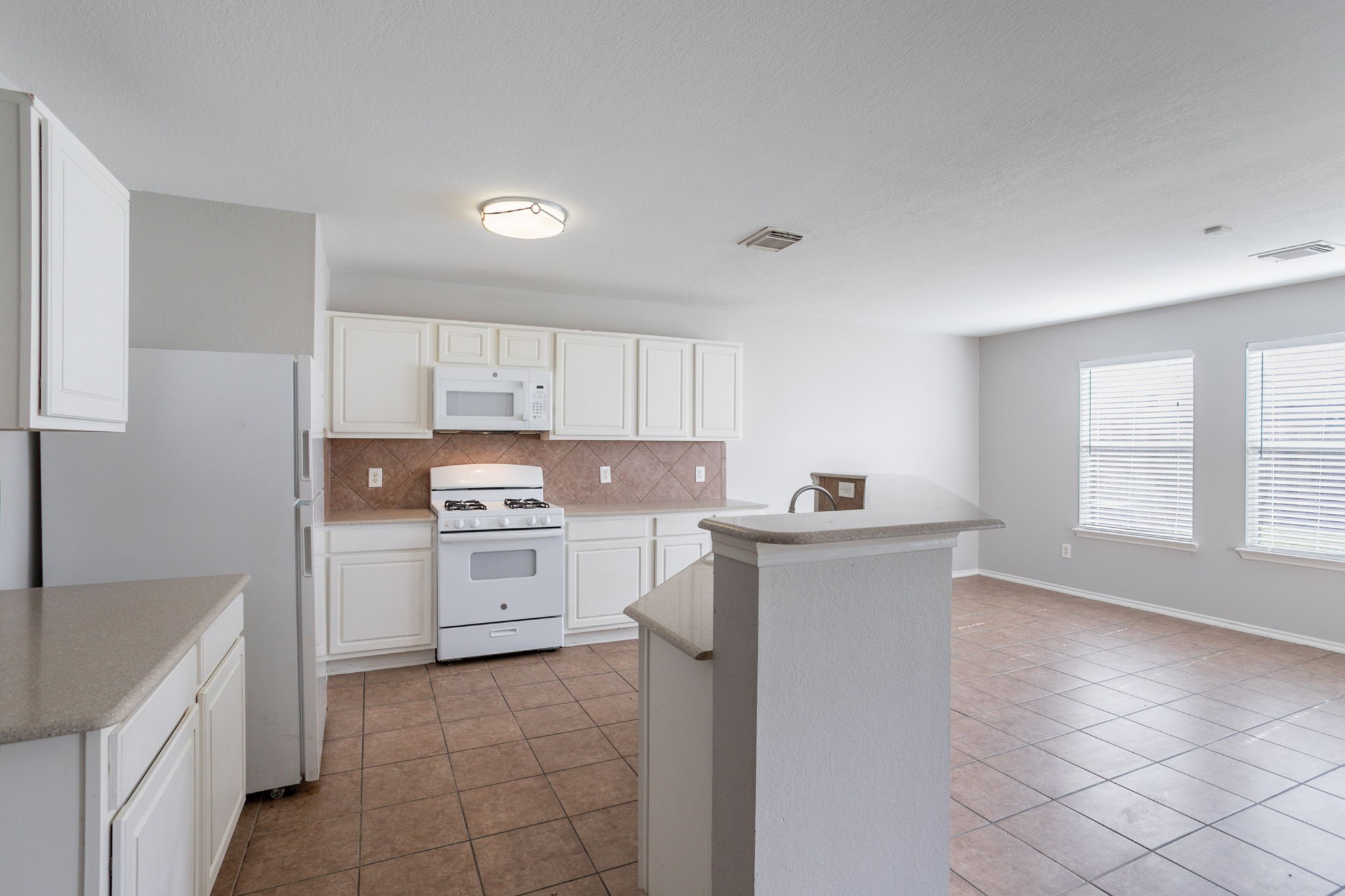 12026 Madison Oak Street Houston, TX 77038 - Photo 18 of 39 a kitchen with a stove top oven sink and cabinets