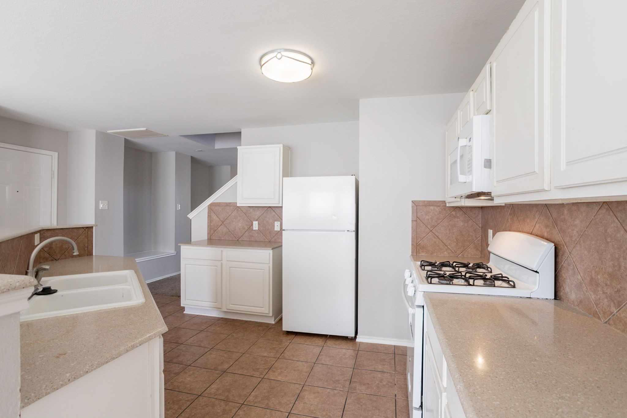 12026 Madison Oak Street Houston, TX 77038 - Photo 19 of 39 a kitchen with a sink and a refrigerator