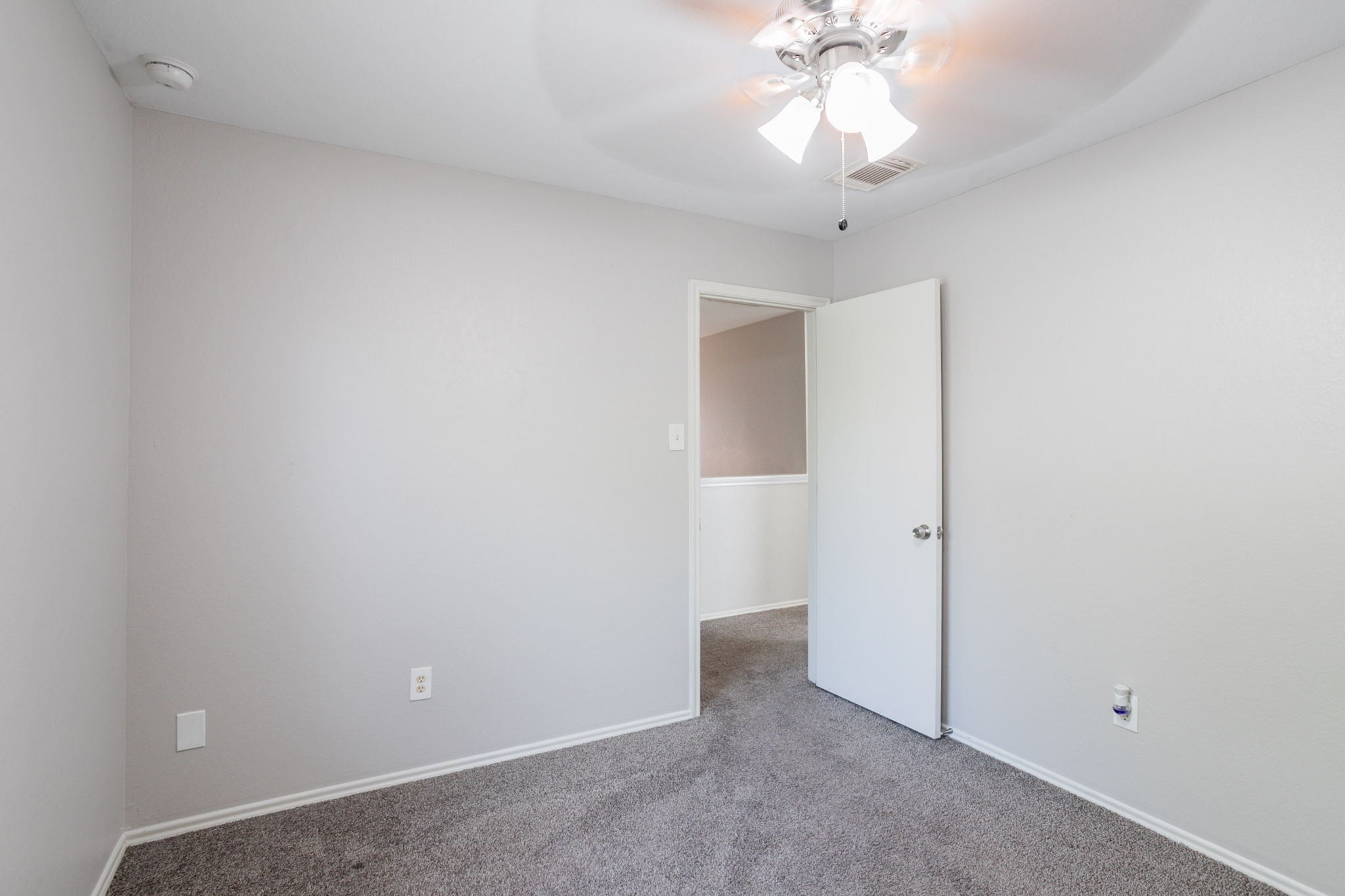 12026 Madison Oak Street Houston, TX 77038 - Photo 27 of 39 an empty room with a ceiling fan and window