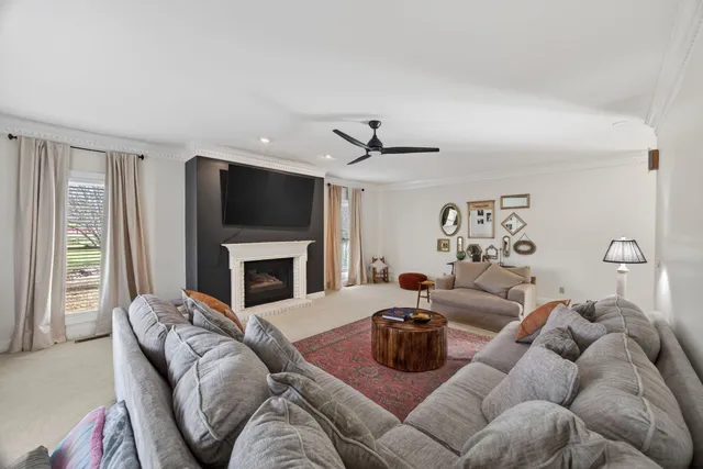 a kitchen with stainless steel appliances kitchen island granite countertop a refrigerator a stove top oven a sink dishwasher and white cabinets with wooden floor