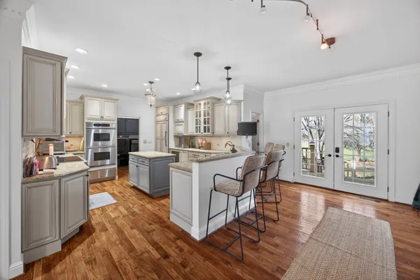 a large kitchen with stainless steel appliances granite countertop a sink stove and refrigerator