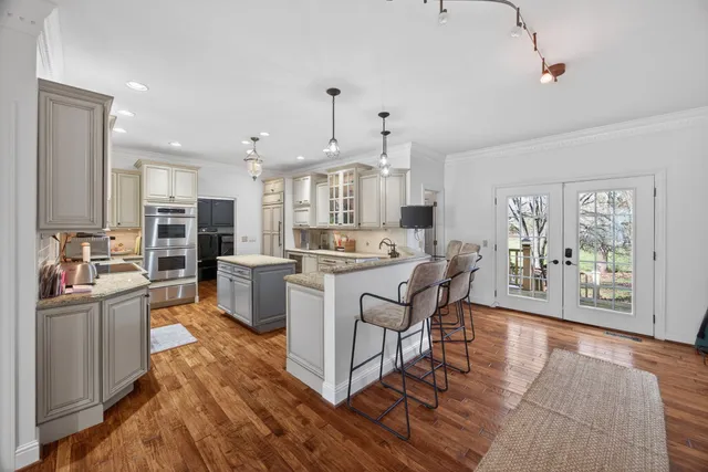 a large kitchen with stainless steel appliances granite countertop a sink stove and refrigerator