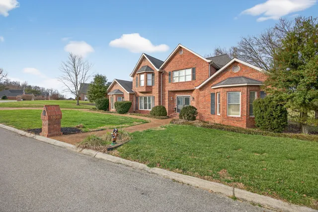 a front view of a house with a yard and trees