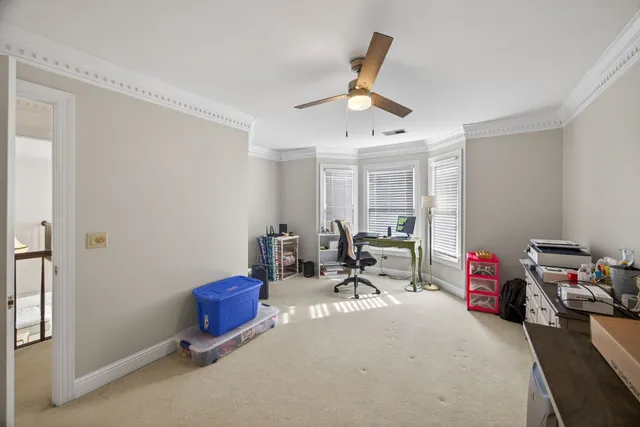 a bed sitting in a spacious bedroom next to a window