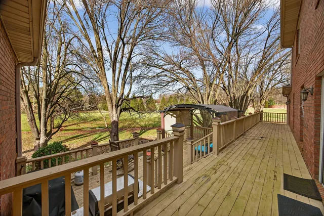 a view of a house with wooden deck and trees