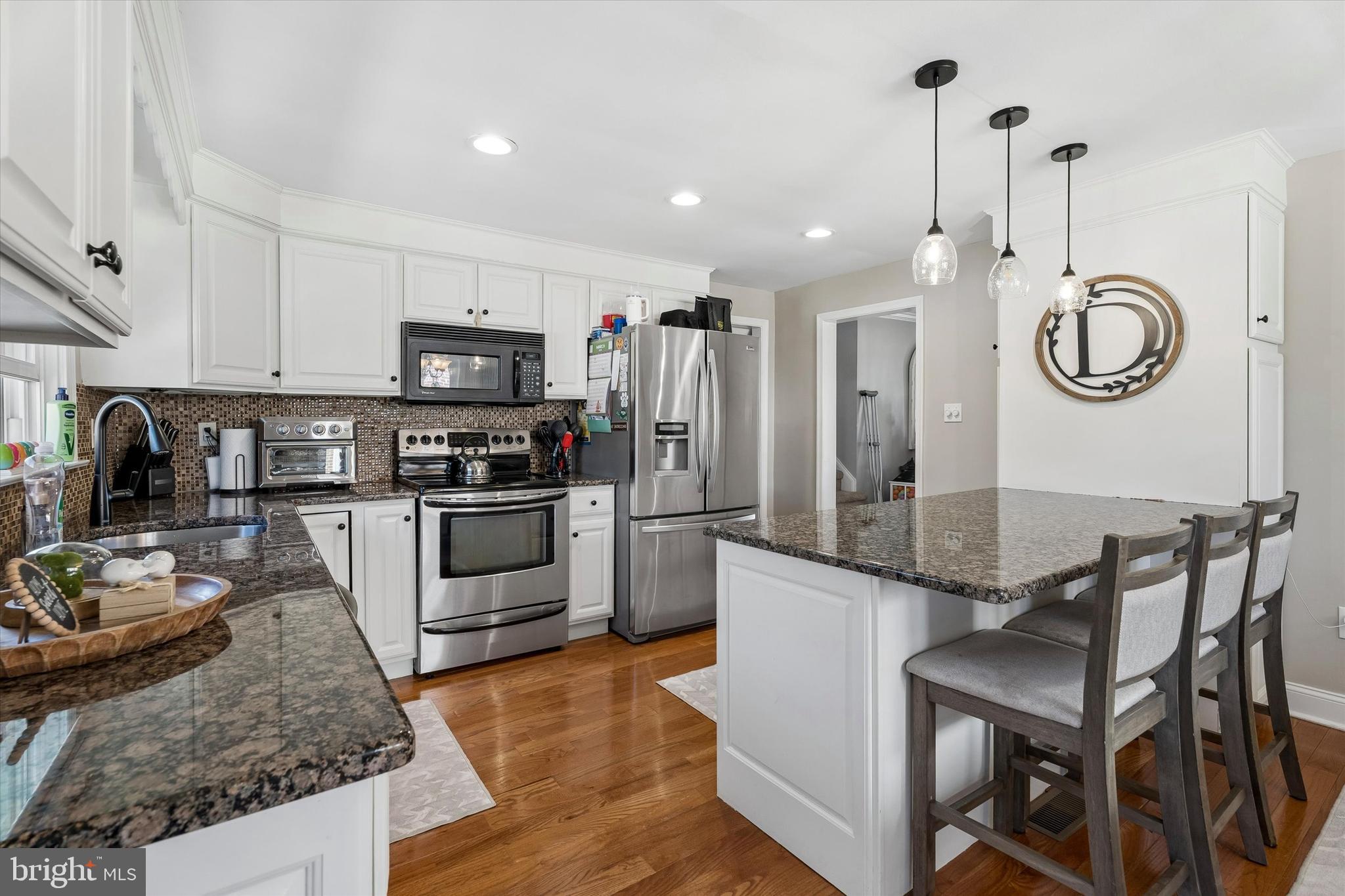249 Gleaves Road Springfield, PA 19064 - Photo 11 of 34 a kitchen with granite countertop stainless steel appliances a stove a sink a microwave a refrigerator and cabinets