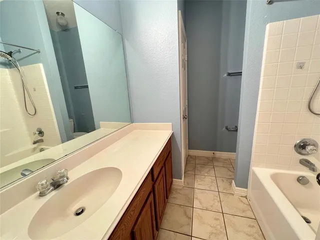 a spacious bathroom with a tub sink and mirror