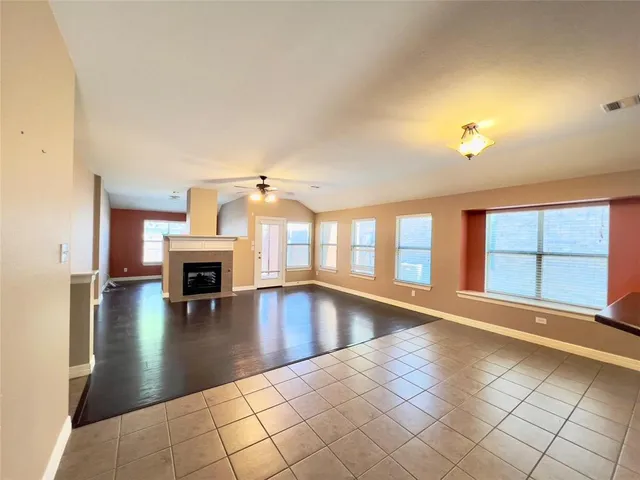 an empty room with fireplace and windows