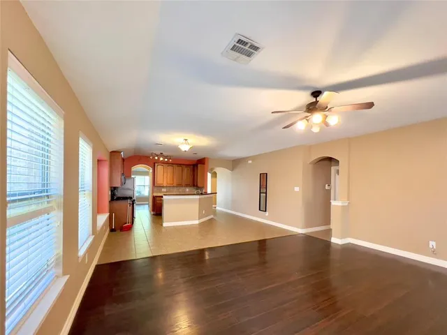 a view of a livingroom with wooden floor and a ceiling fan