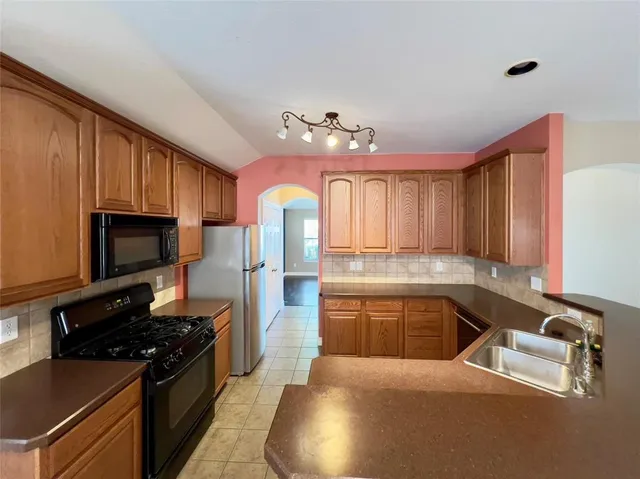 a kitchen with stainless steel appliances granite countertop a stove refrigerator and microwave