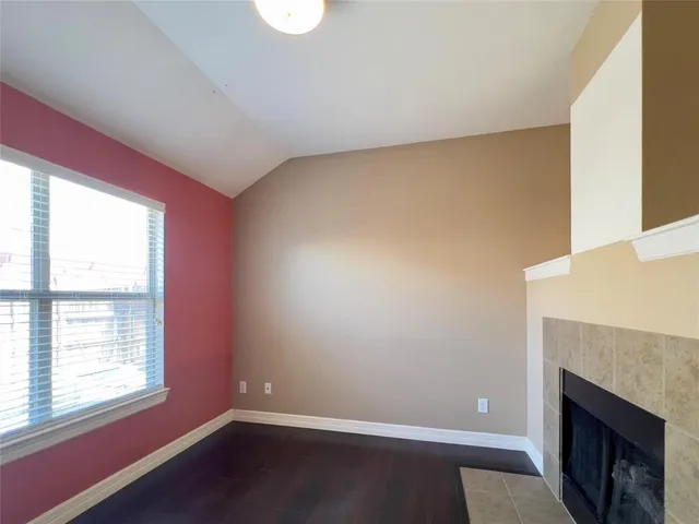 a view of empty room with wooden floor and fireplace