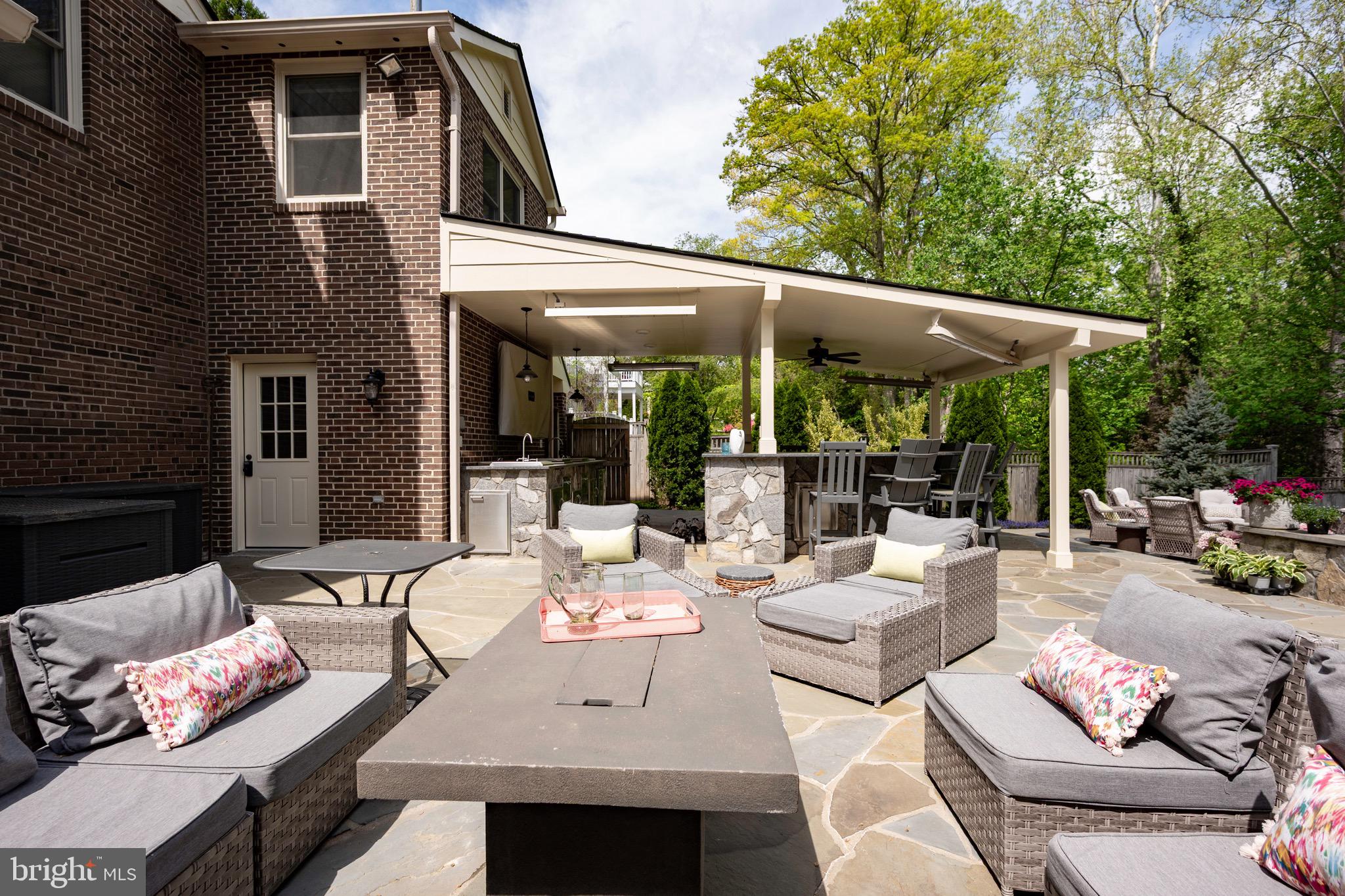 902 Emerald Drive Alexandria, VA 22308 - Photo 61 of 97 a view of a patio with table and chairs under an umbrella with a large tree
