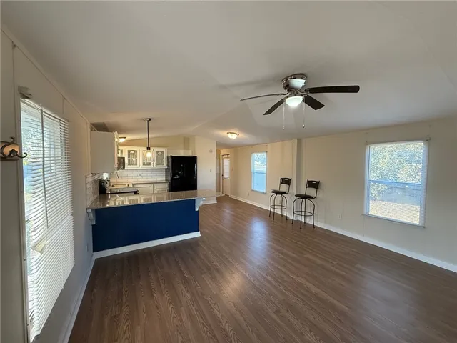 a large kitchen with stainless steel appliances kitchen island wooden floors and view living room