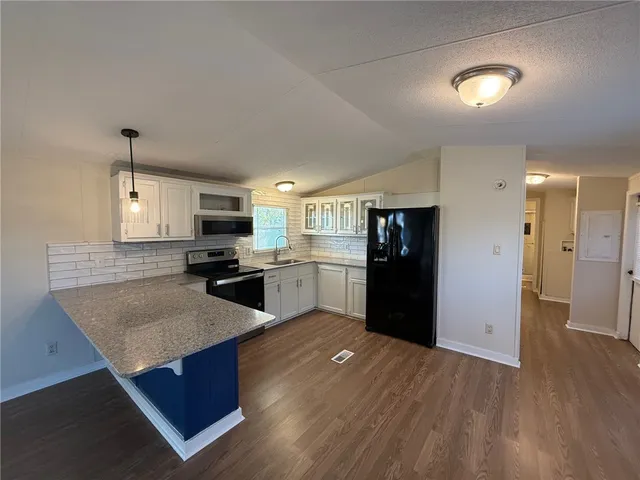 a kitchen with a refrigerator and a stove top oven