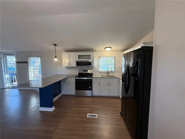 a kitchen with granite countertop stainless steel appliances and a refrigerator