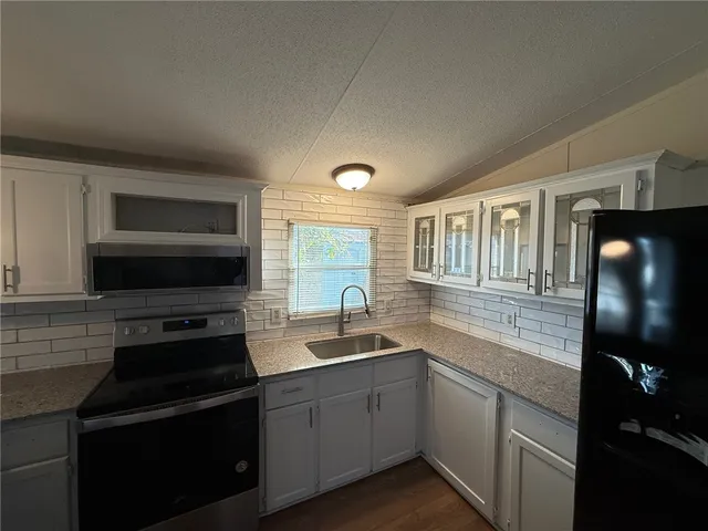a kitchen with a sink stove and microwave
