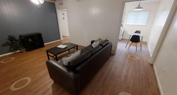 a living room with furniture and a wooden floor