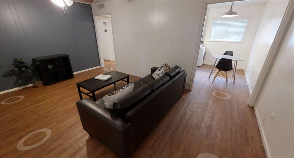 3011 Whitis Avenue, Unit 204 Austin, TX 78705 - Photo 2 of 6 Living room featuring wood finished floors, a ceiling fan, and wooden walls