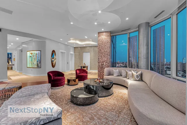 a large living room with stainless steel appliances granite countertop a couch a bookshelf a counter space and a large window