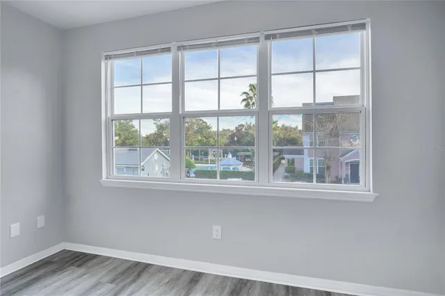 an empty room with wooden floor and a window