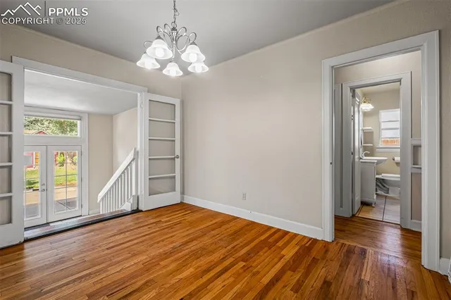 a view of a room with wooden floor staircase and a kitchen space