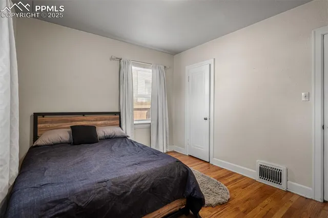 a bedroom with a bed and wooden floor