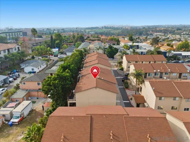 an aerial view of residential houses with outdoor space and ocean view