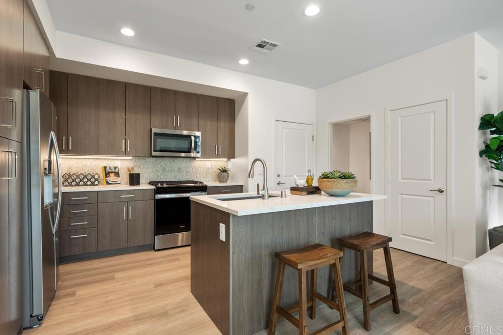 2060 Paseo Belluno, Unit 6 Chula Vista, CA 91913 - Photo 38 of 64 a kitchen with a sink stainless steel appliances and cabinets