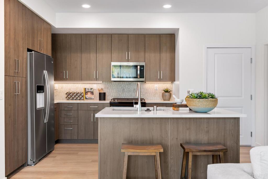 2060 Paseo Belluno, Unit 6 Chula Vista, CA 91913 - Photo 39 of 64 a kitchen with stainless steel appliances granite countertop a refrigerator sink and stove
