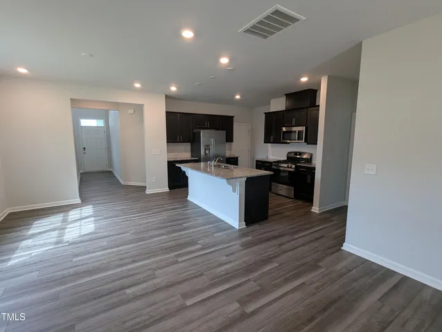 a large kitchen with stainless steel appliances granite countertop a stove and a sink