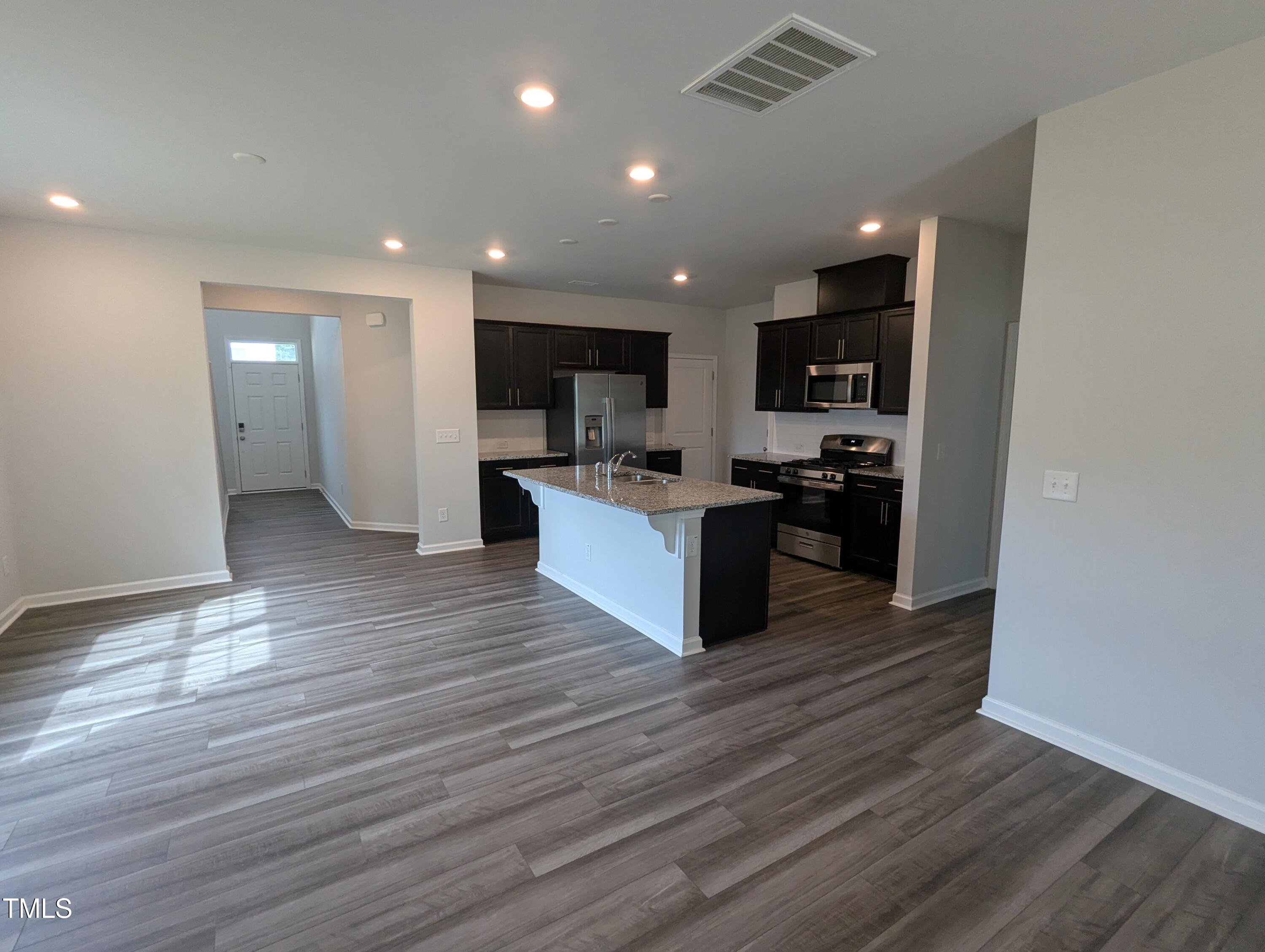 4020 Whitney Peak Drive Raleigh, NC 27616 - Photo 5 of 21 a large kitchen with stainless steel appliances granite countertop a stove and a sink