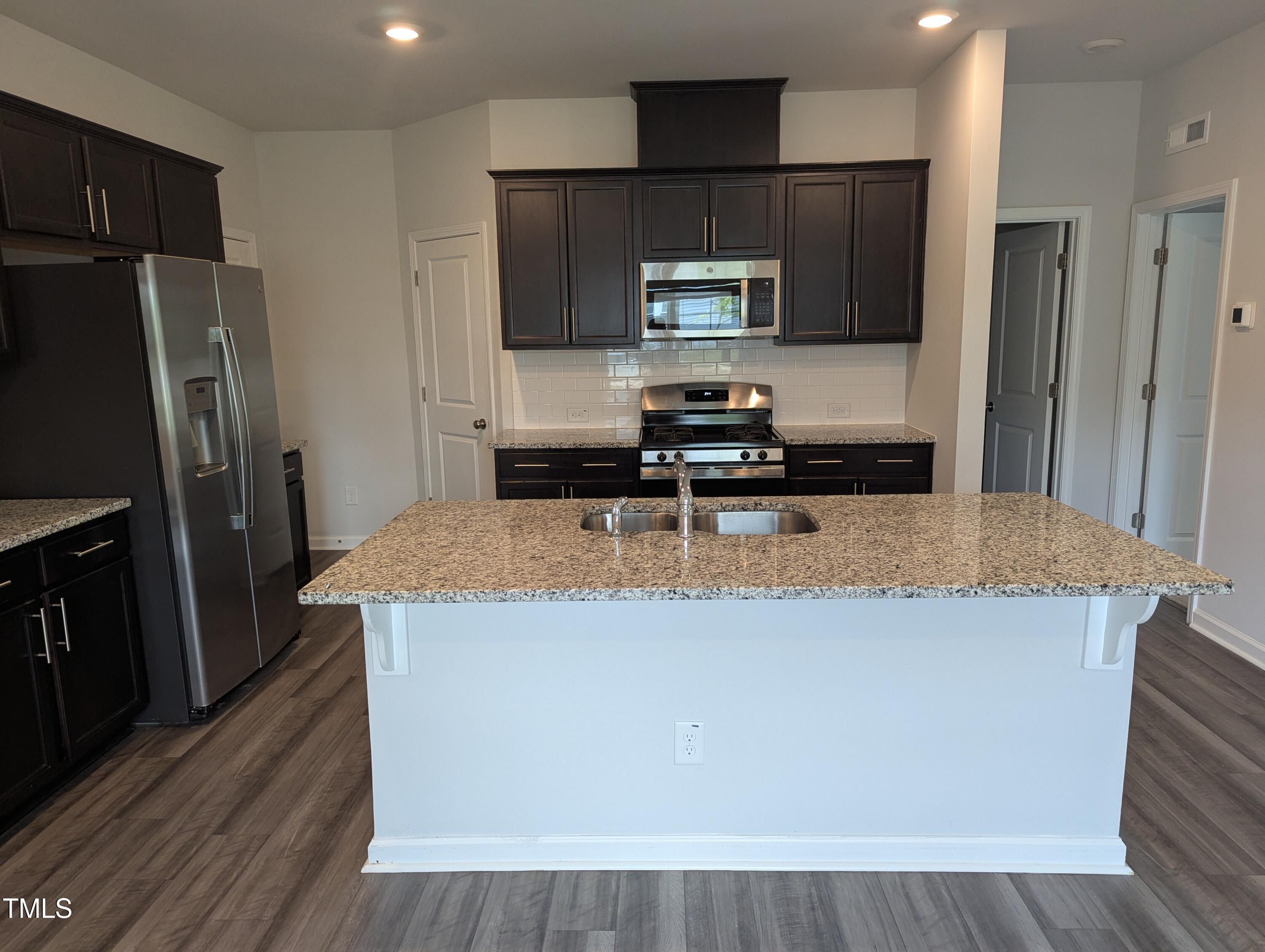 4020 Whitney Peak Drive Raleigh, NC 27616 - Photo 6 of 21 a kitchen with kitchen island a sink stainless steel appliances and refrigerator