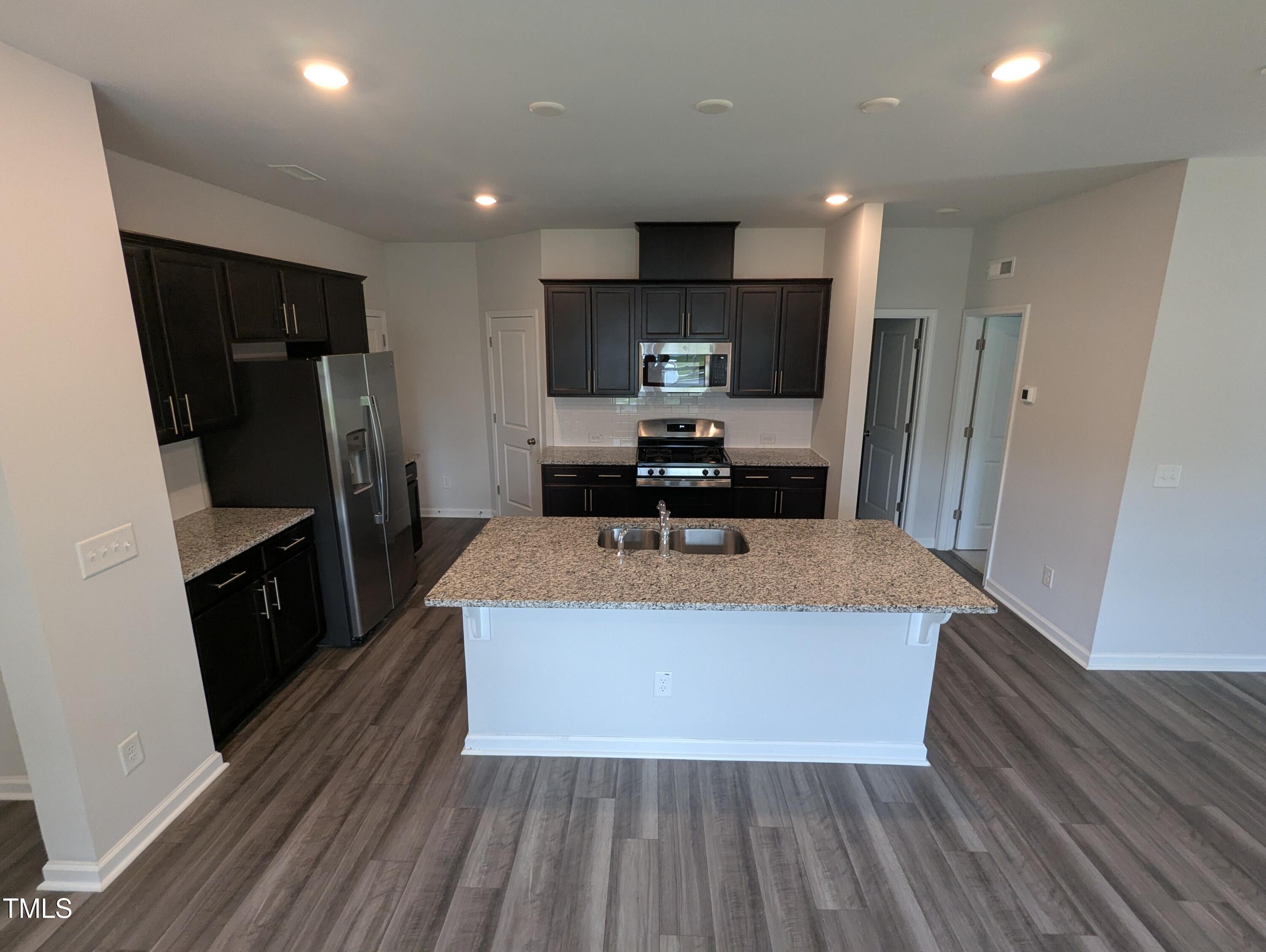 4020 Whitney Peak Drive Raleigh, NC 27616 - Photo 7 of 21 a kitchen with stainless steel appliances a refrigerator a sink a stove a microwave and wooden floor