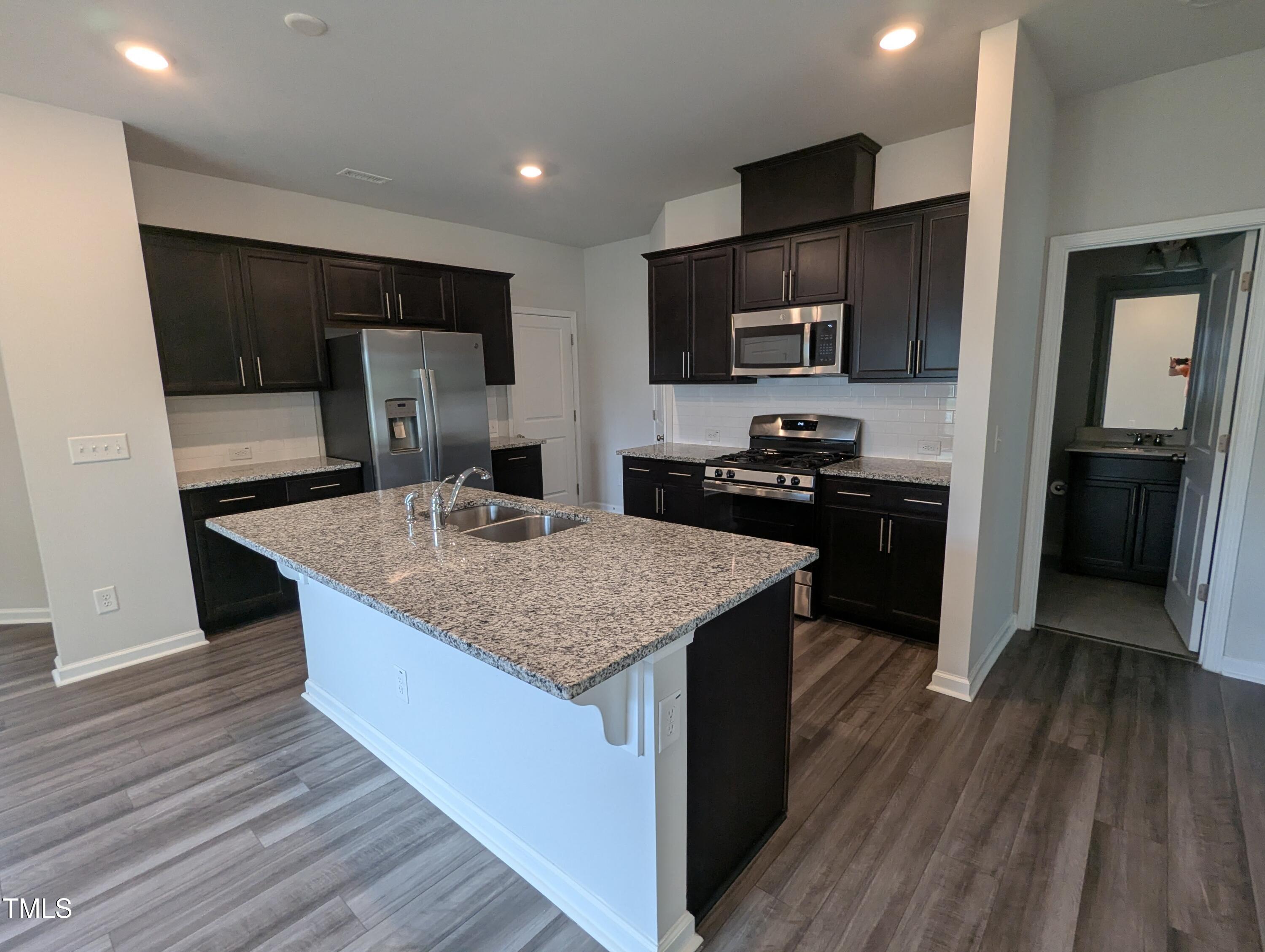 4020 Whitney Peak Drive Raleigh, NC 27616 - Photo 8 of 21 a kitchen with stainless steel appliances granite countertop a sink stove and refrigerator