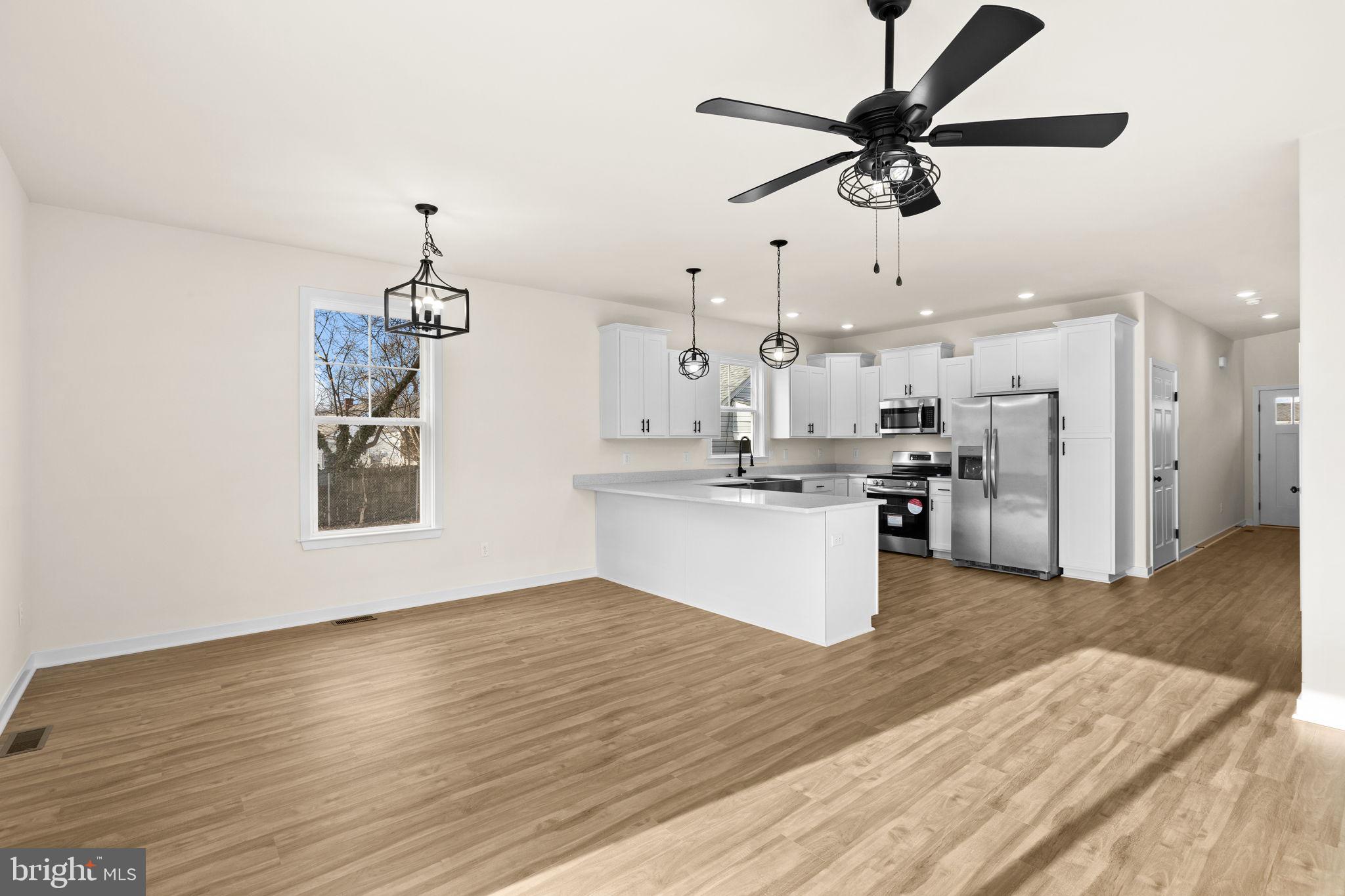 165 Bend Farm Road Fredericksburg, VA 22408 - Photo 21 of 51 a view of kitchen with stainless steel appliances kitchen island granite countertop a refrigerator a stove and white cabinets with wooden floor