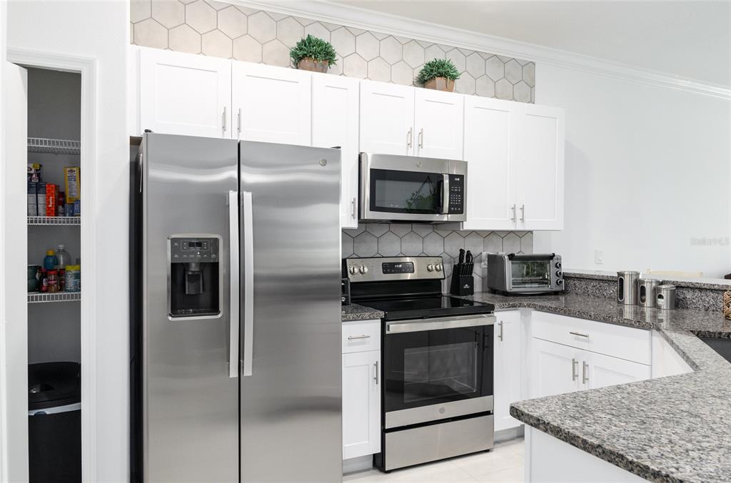 6736 Ripple Pond Loop Zephyrhills, FL 33541 - Photo 15 of 40 a kitchen with stainless steel appliances a refrigerator stove and microwave