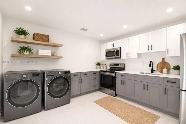 a kitchen with cabinets stainless steel appliances and wooden floor