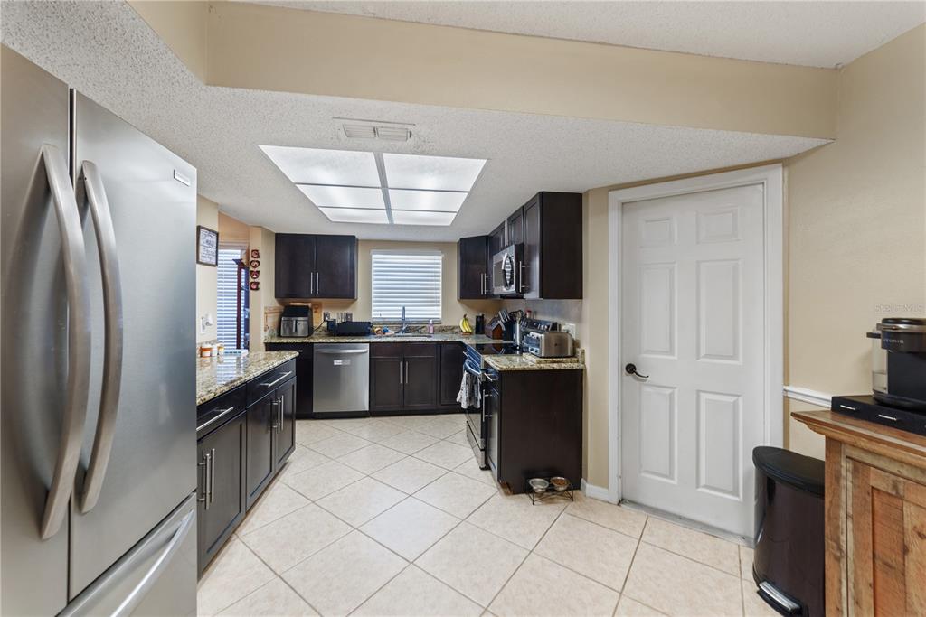 8715 Huntsman Lane Port Richey, FL 34668 - Photo 12 of 54 a kitchen with granite countertop a refrigerator stove and sink