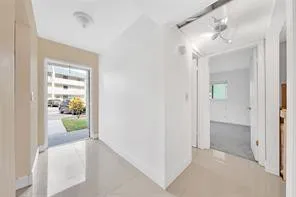 an empty room with windows and refrigerator