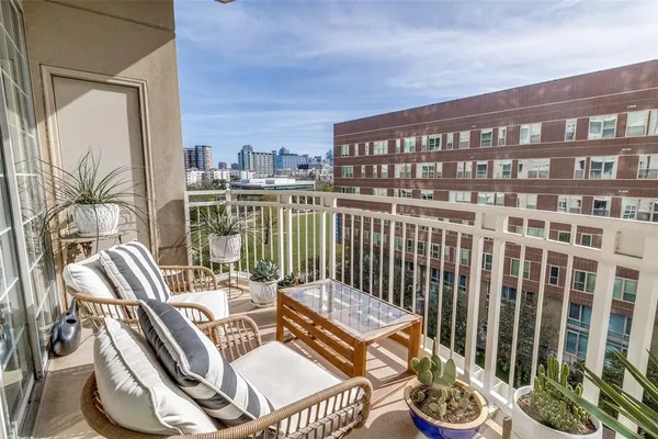 a view of a balcony with chairs and a potted plant