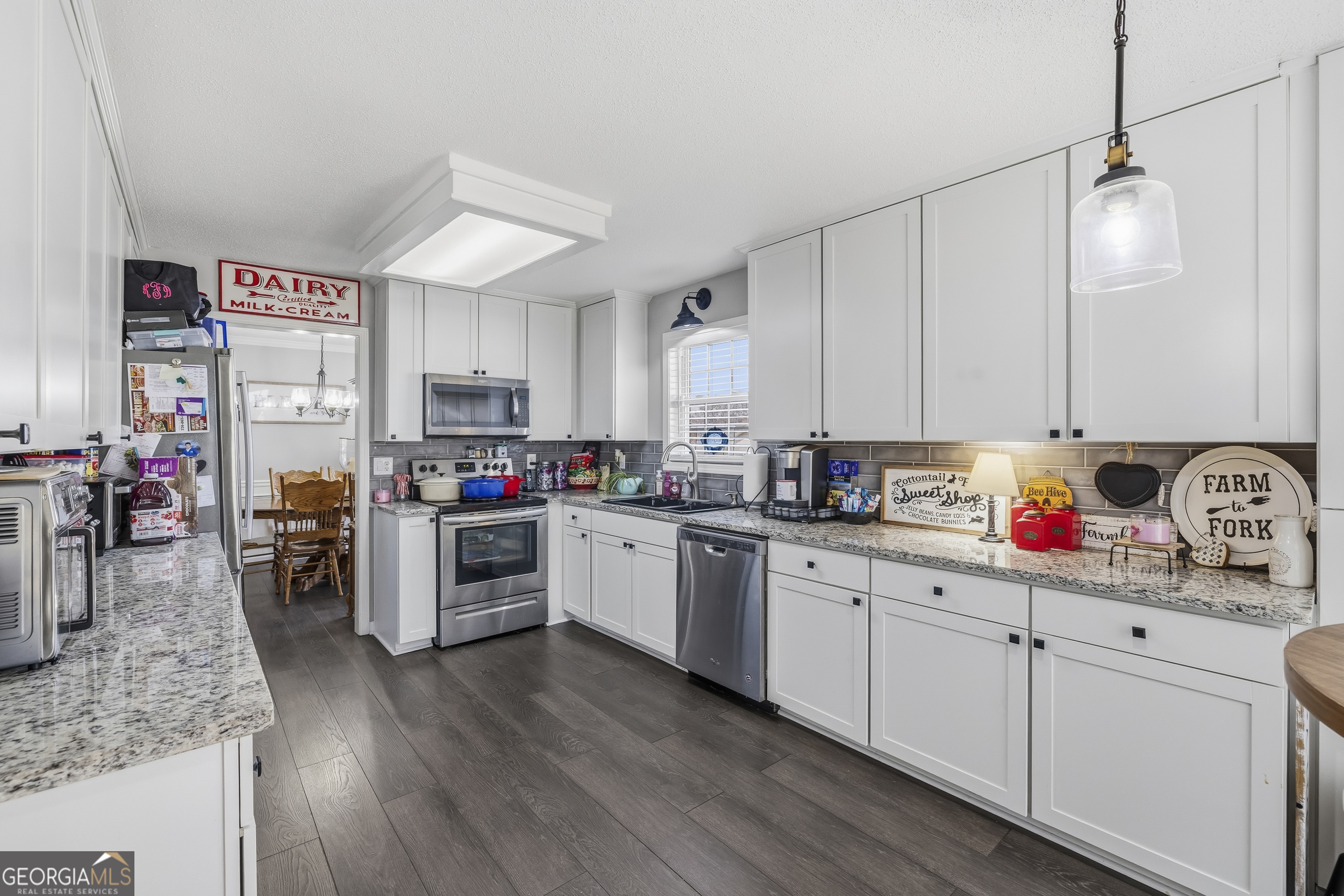460 Flyway Lane Winder, GA 30680 - Photo 10 of 32 a kitchen with granite countertop white cabinets and white appliances